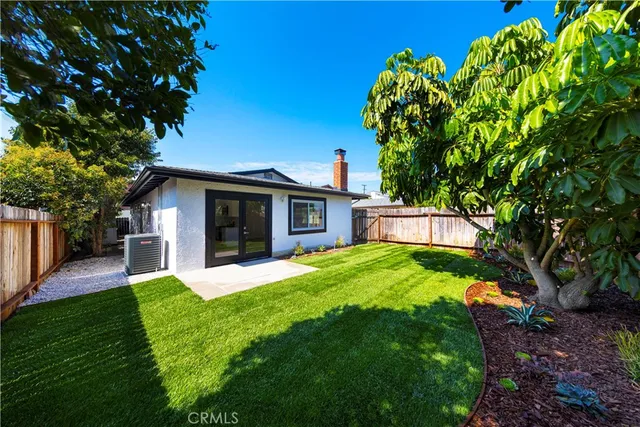 a front view of a house with a yard and trees