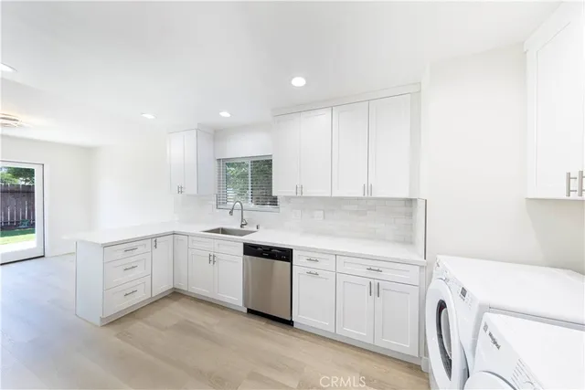 a kitchen with white cabinets and sink