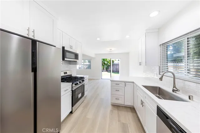 a kitchen with a sink stainless steel appliances and cabinets