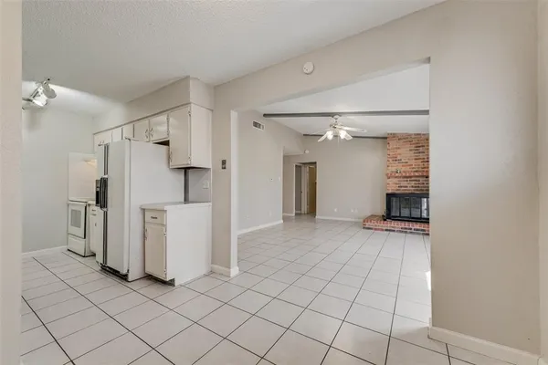 a view of a storage & utility room with refrigerator and window
