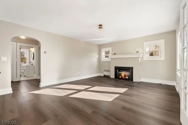 a view of a livingroom with wooden floor and a fireplace