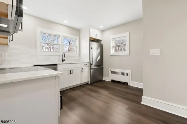 a kitchen with cabinets and wooden floor