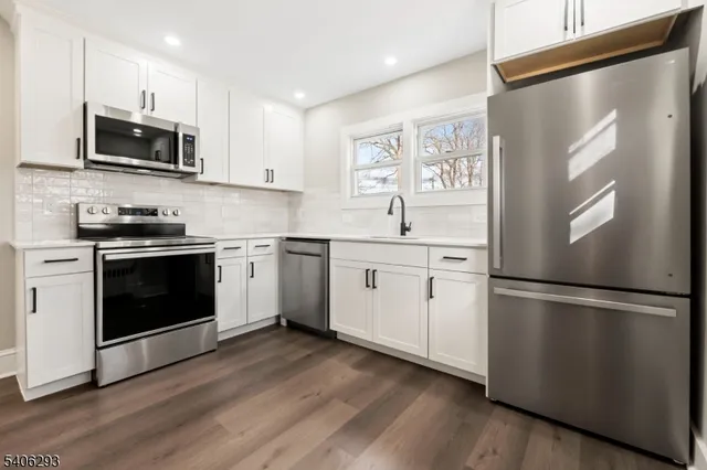 a kitchen with stainless steel appliances white cabinets and a sink
