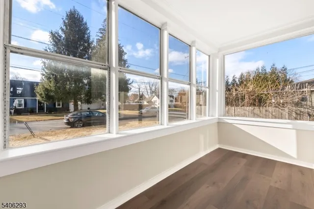 a view of a room with a large window and wooden floor