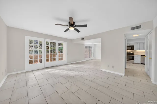 a view of a livingroom with a ceiling fan and window