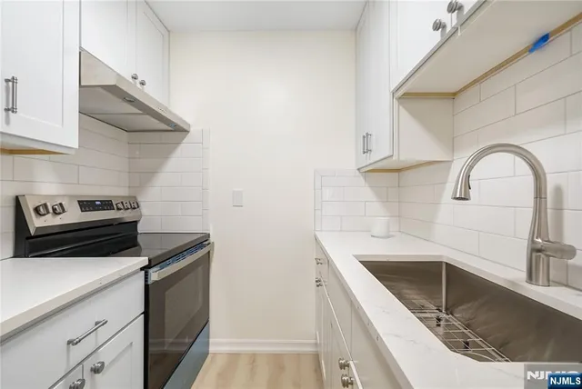 a kitchen with a sink and a stove top oven
