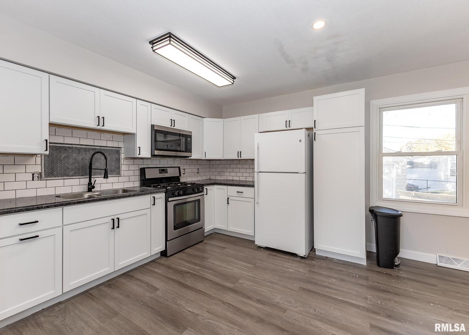 1430 4th Street Camanche, IA 52730 - Photo 8 of 22 a kitchen with granite countertop white cabinets and white appliances