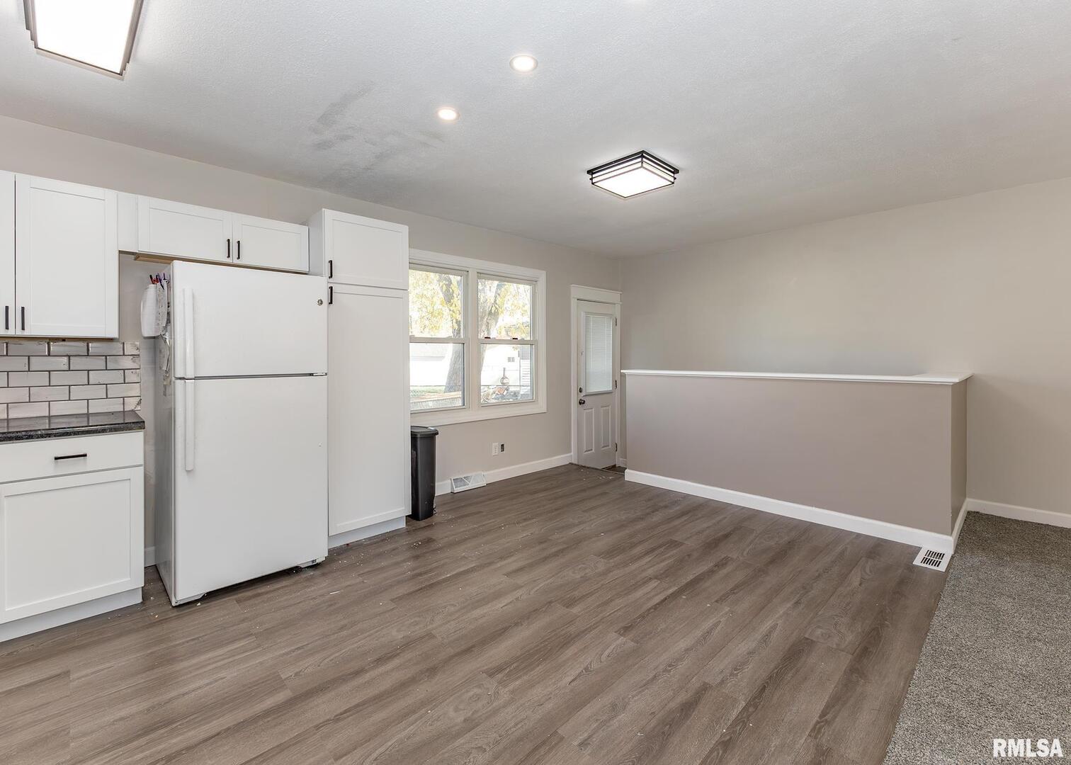 1430 4th Street Camanche, IA 52730 - Photo 9 of 22 a view of a kitchen with a refrigerator a stove top oven and cabinets