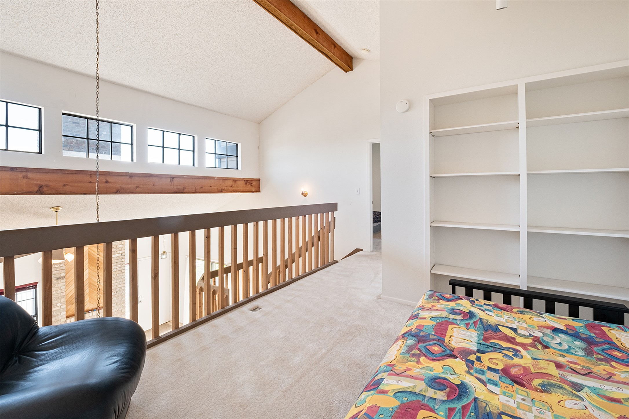 1748 Ohlen Road, Unit 16 Austin, TX 78757 - Photo 24 of 38 a bedroom with furniture and a book shelf
