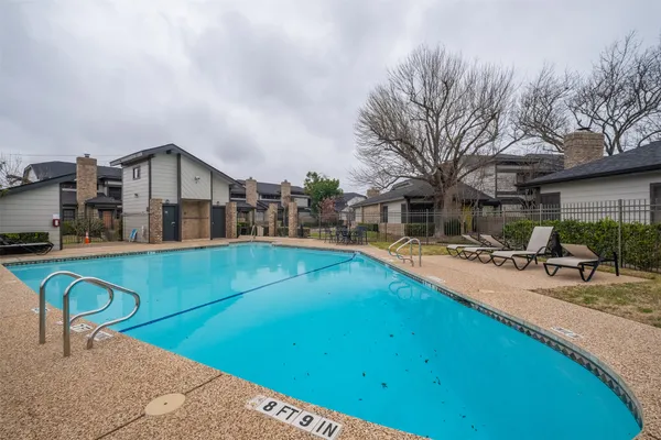 a view of a house with pool and chairs
