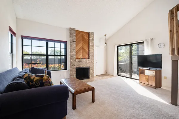 a living room with furniture a flat screen tv and a floor to ceiling window