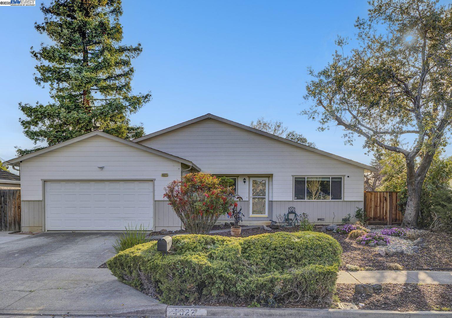 a front view of house with yard and trees in the background