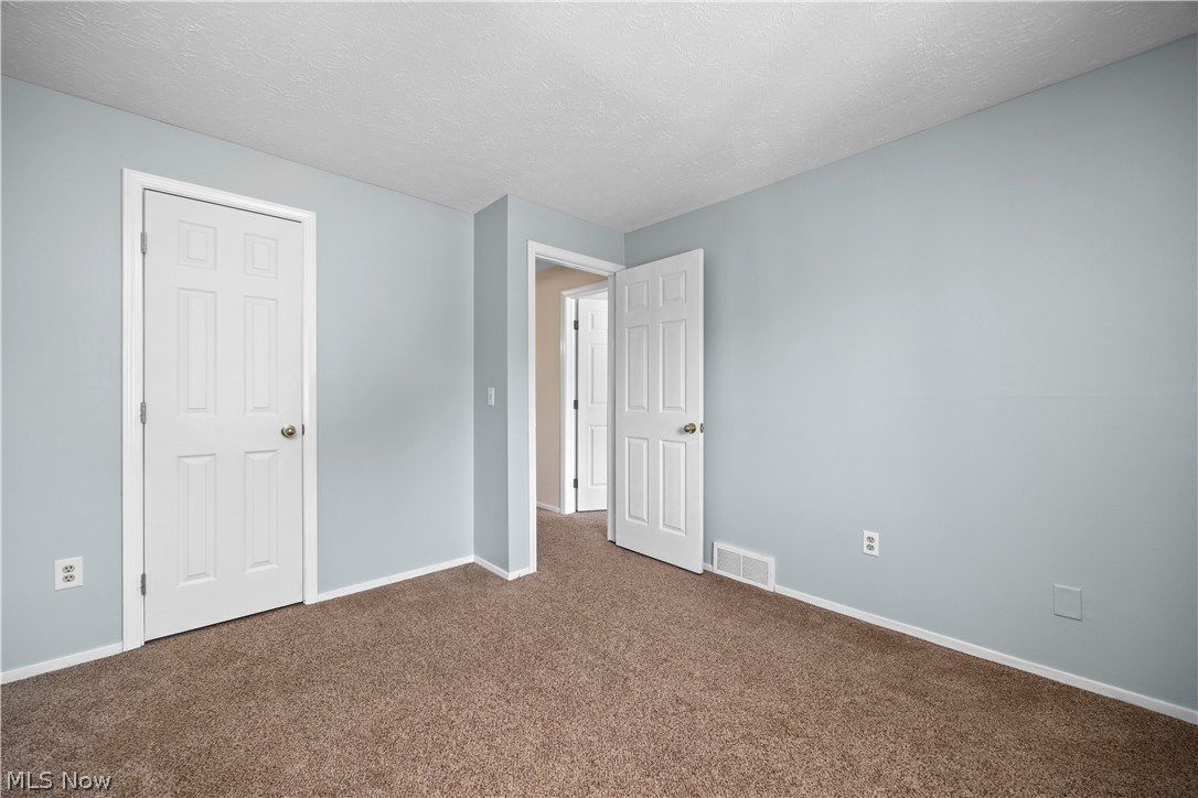 216 Moore Road Avon Lake, OH 44012 - Photo 17 of 22 Neutral tone wall paint, textured ceiling, and carpet flooring
