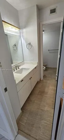a bathroom with a granite countertop toilet and a sink