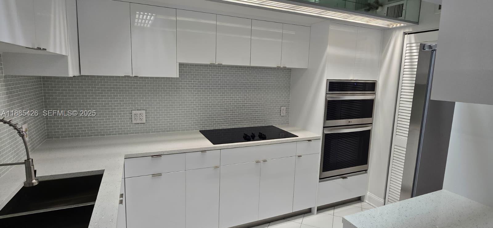 2843 South Bayshore Drive, Unit 3A Miami, FL 33133 - Photo 3 of 43 a kitchen with a sink and white cabinets