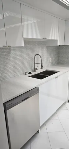 a kitchen with a sink a stove and cabinets