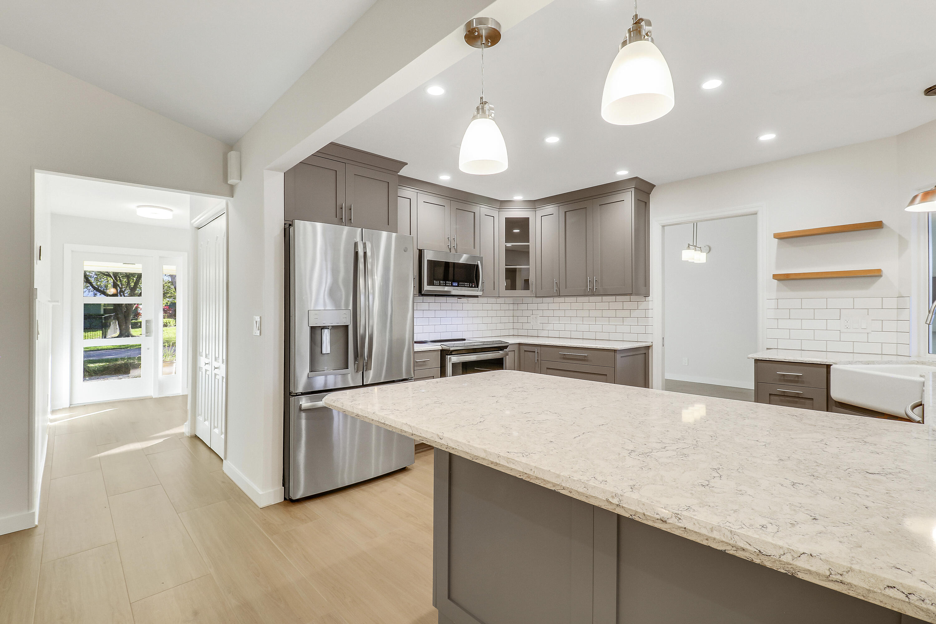 5775 Set-N-Sun Place Jupiter, FL 33458 - Photo 13 of 54 a large kitchen with stainless steel appliances a large counter top a stove and a refrigerator