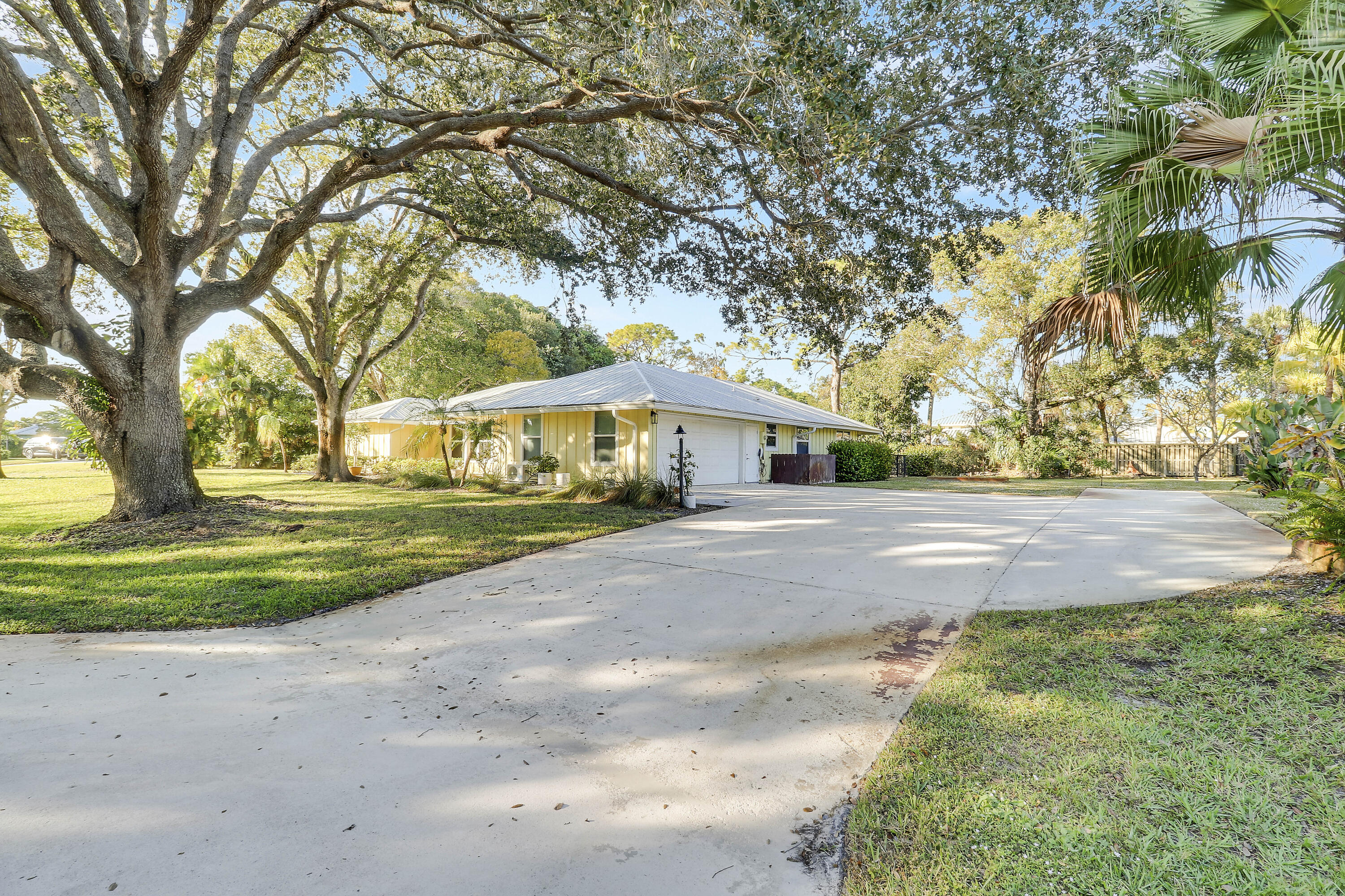 5775 Set-N-Sun Place Jupiter, FL 33458 - Photo 4 of 54 a front view of a house with yard and green space