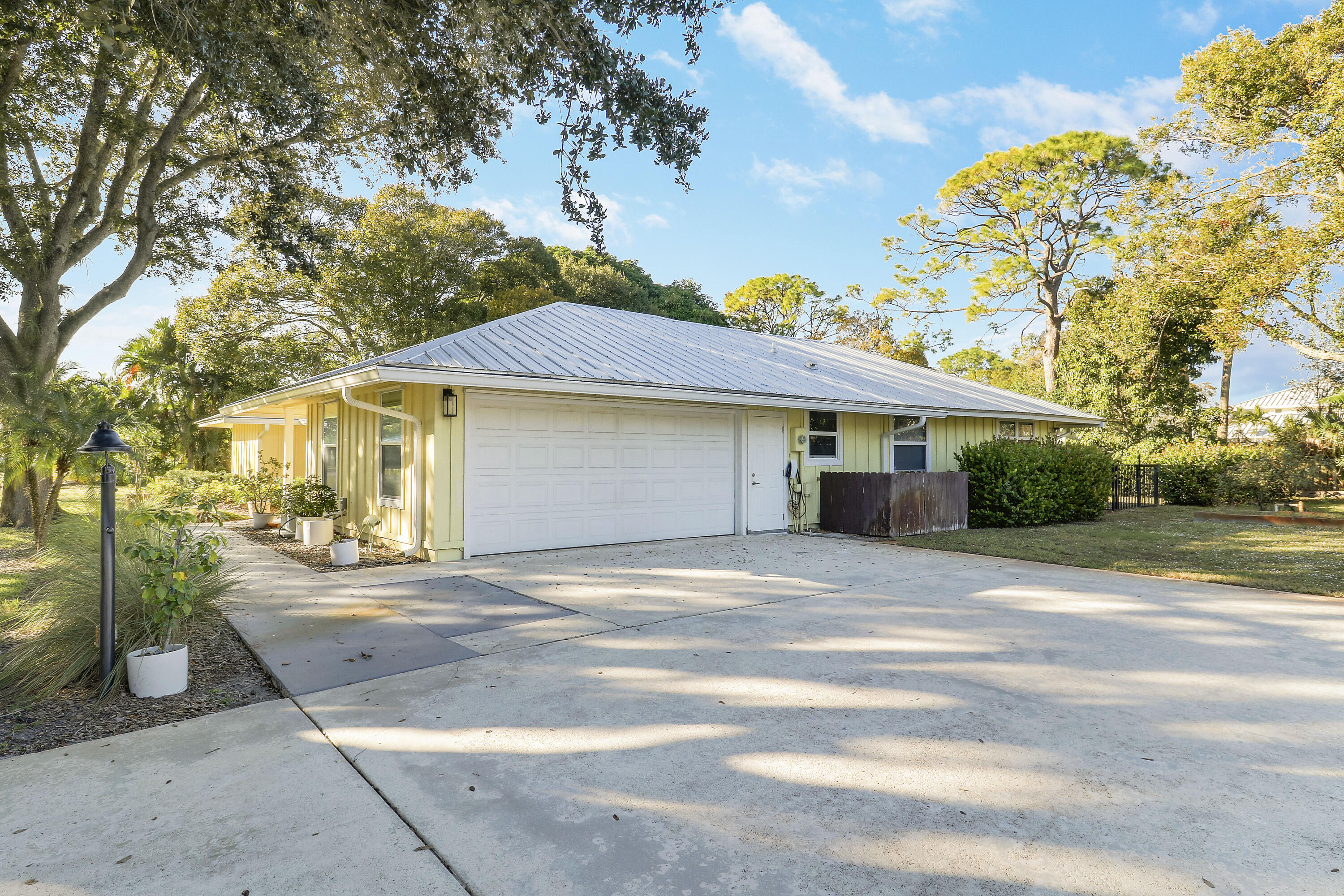5775 Set-N-Sun Place Jupiter, FL 33458 - Photo 6 of 54 a front view of a house with a yard and potted plants