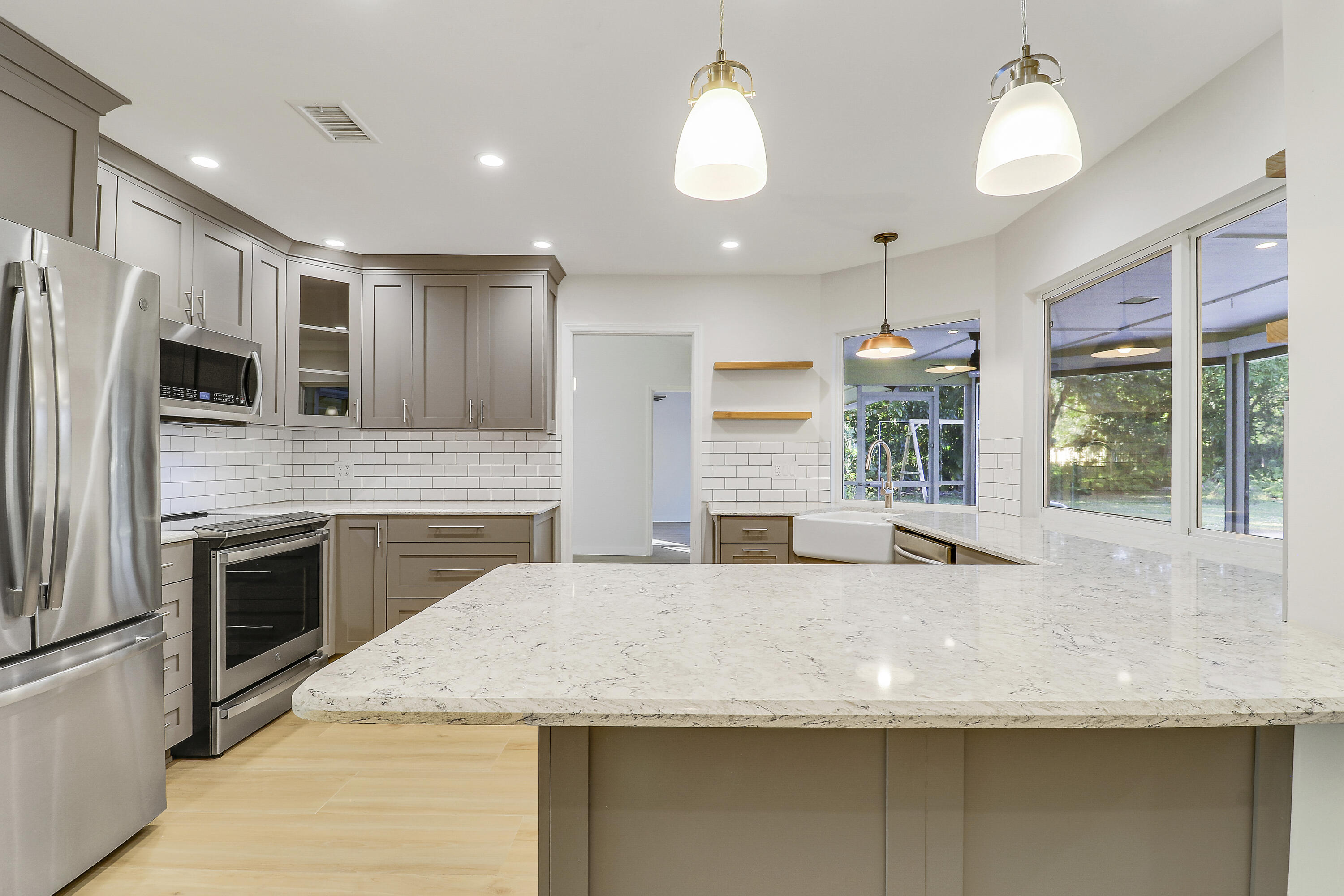 5775 Set-N-Sun Place Jupiter, FL 33458 - Photo 8 of 54 a large kitchen with stainless steel appliances granite countertop a sink a stove and a refrigerator