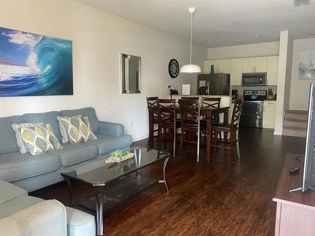a living room with furniture a dining table and kitchen view