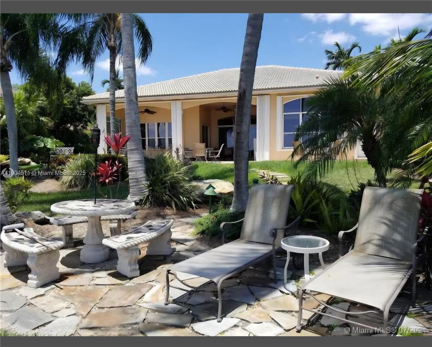 4045 Southwest 151st Terrace Miramar, FL 33027 - Photo 28 of 29 a view of a patio with table and chairs potted plants and palm tree