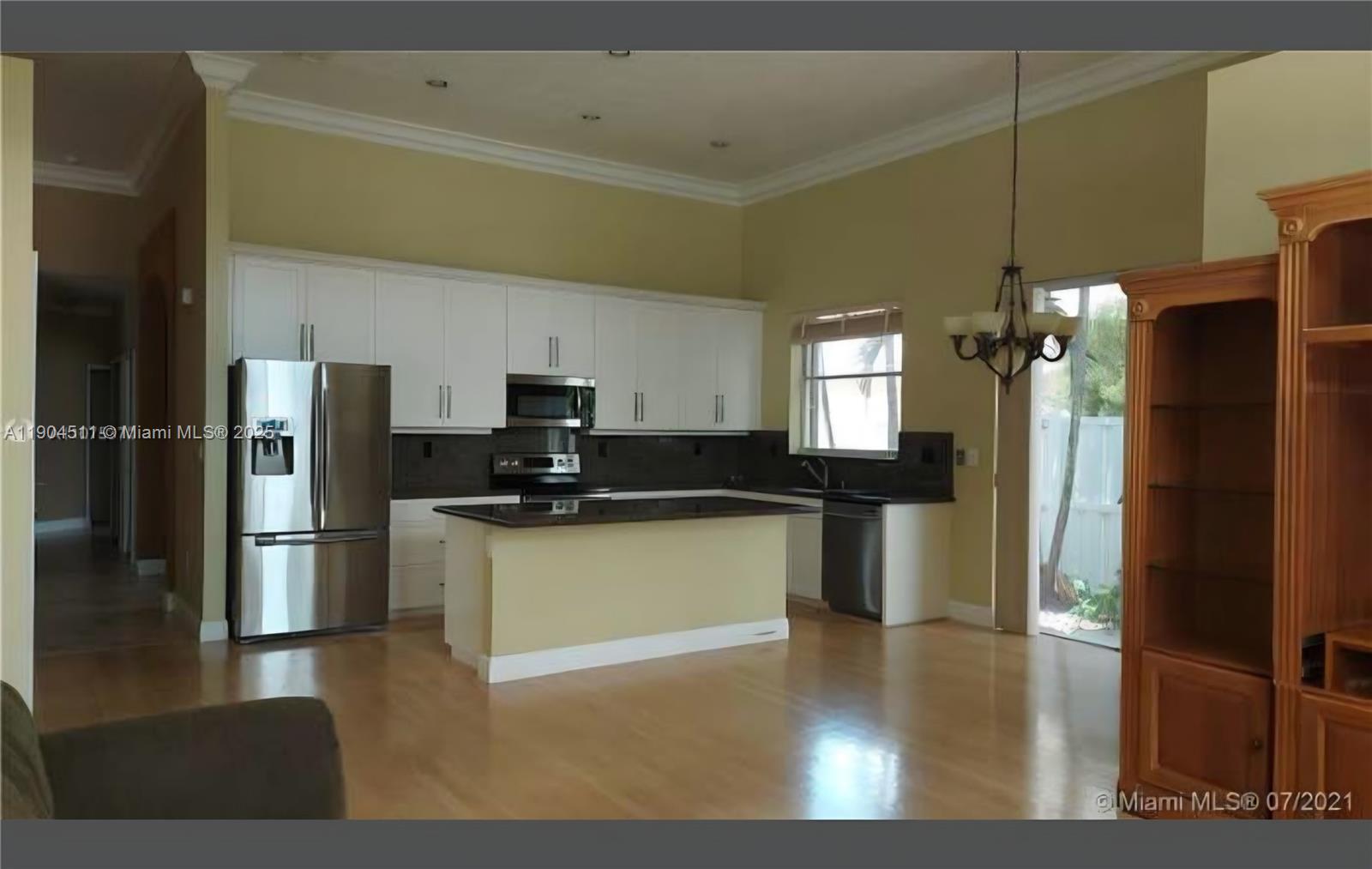 4045 Southwest 151st Terrace Miramar, FL 33027 - Photo 7 of 29 a kitchen with a refrigerator and a sink