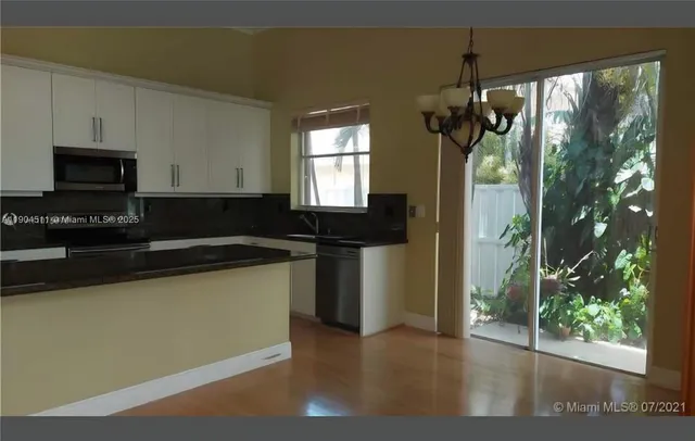 a kitchen with a sink a microwave and cabinets