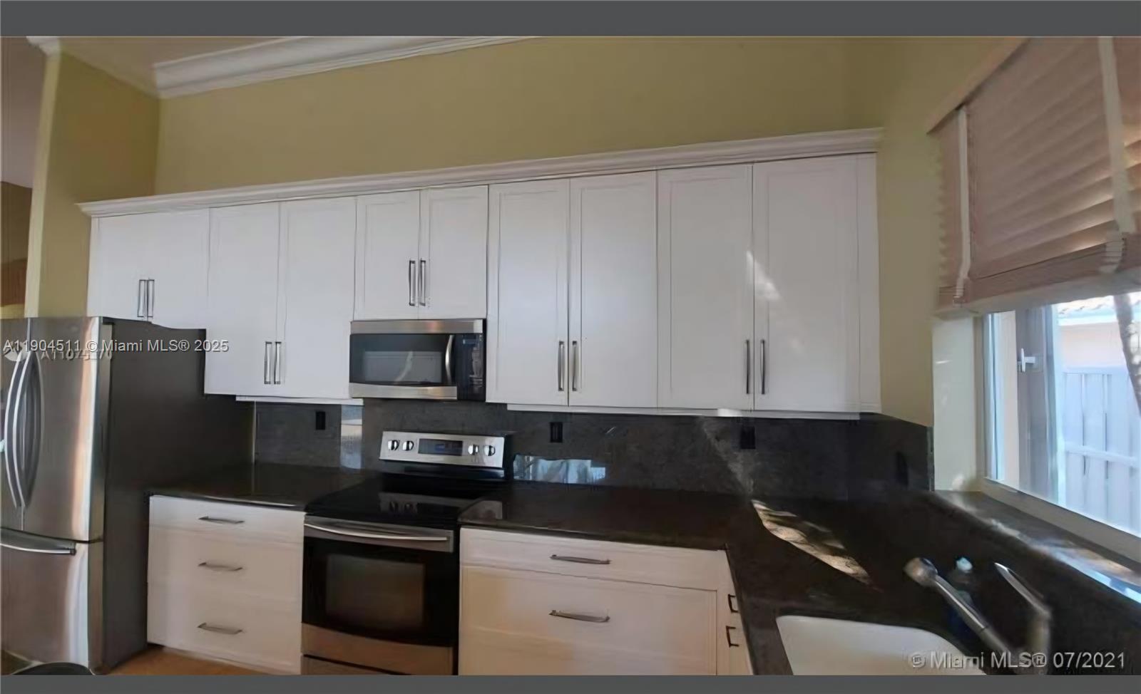4045 Southwest 151st Terrace Miramar, FL 33027 - Photo 10 of 29 a kitchen with granite countertop white cabinets and stainless steel appliances