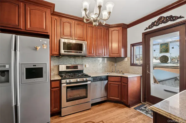 a kitchen with stainless steel appliances granite countertop a stove microwave and refrigerator
