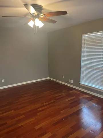 a view of a room with wooden floor and fan