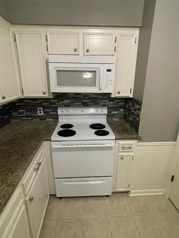a stove top oven sitting inside of a kitchen