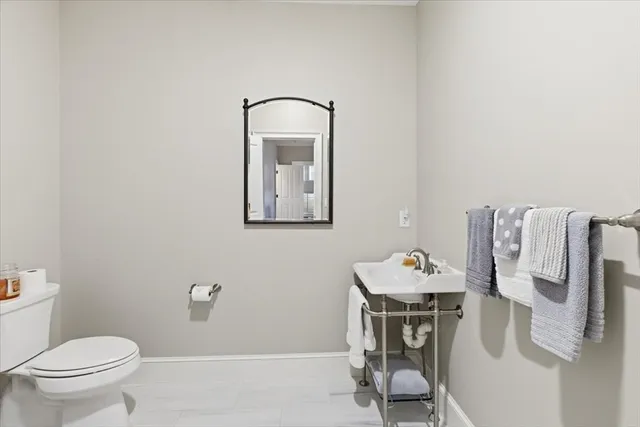 a bathroom with a toilet sink and mirror