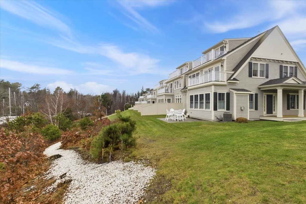 1090 Shore Road, Unit 7 Bourne, MA 02559 - Photo 39 of 42 a view of a big house with a big yard and large trees