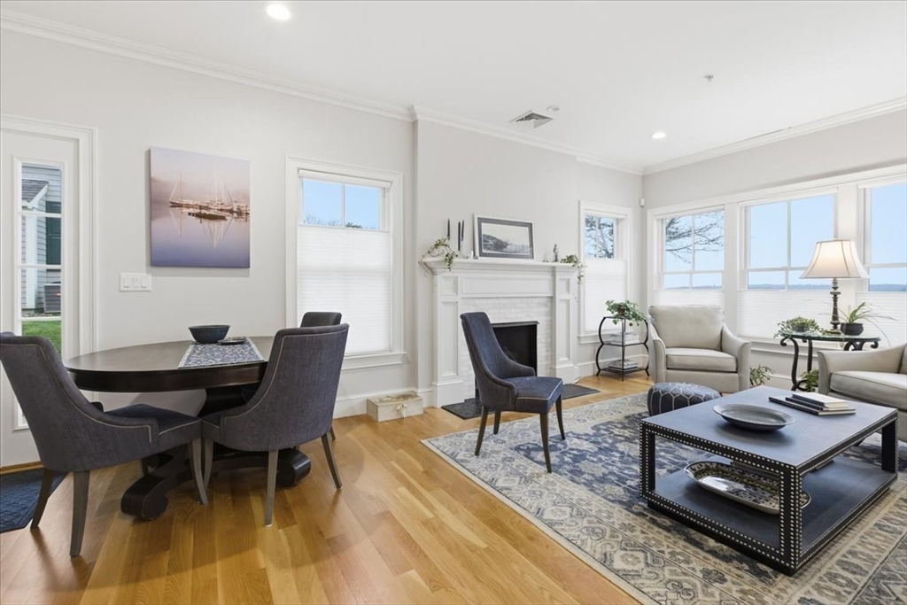 1090 Shore Road, Unit 7 Bourne, MA 02559 - Photo 4 of 42 a living room with furniture a table and a fireplace