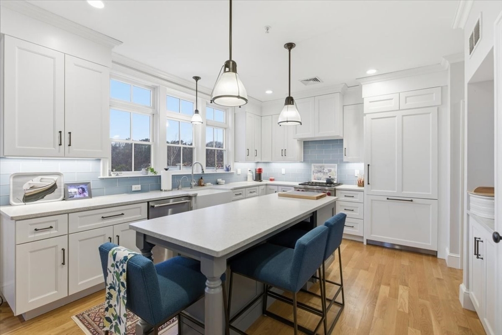 1090 Shore Road, Unit 7 Bourne, MA 02559 - Photo 8 of 42 a kitchen with a table chairs stove and cabinets