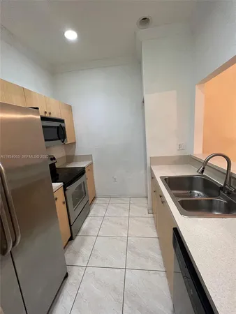 a kitchen that has a sink and a stove top oven