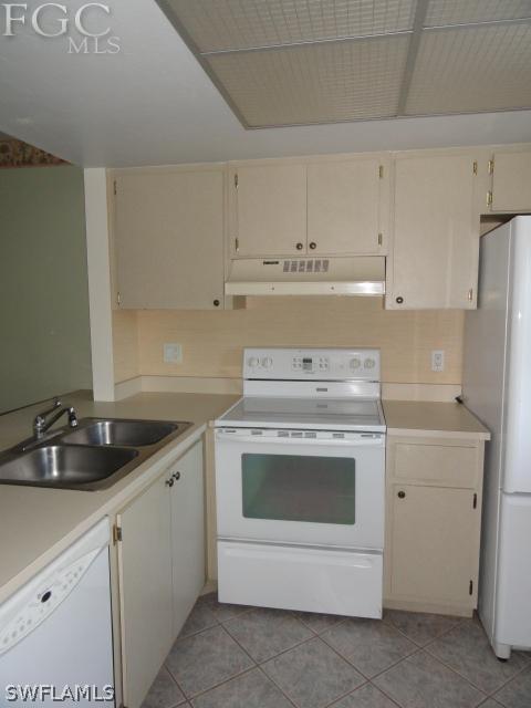 1231 Barrett Road, Unit 1004 North Fort Myers, FL 33903 - Photo 3 of 12 a kitchen with white cabinets and white appliances