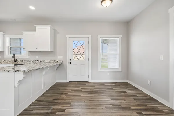 a view of a kitchen with granite countertop cabinets and wooden floor