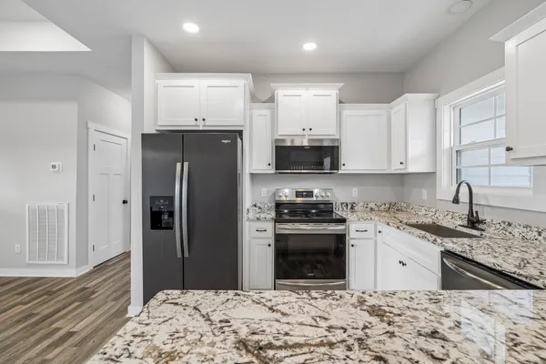 a kitchen with stainless steel appliances granite countertop a refrigerator stove microwave and sink
