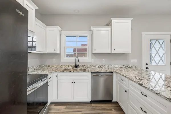 a kitchen with stainless steel appliances granite countertop a sink stove and cabinets