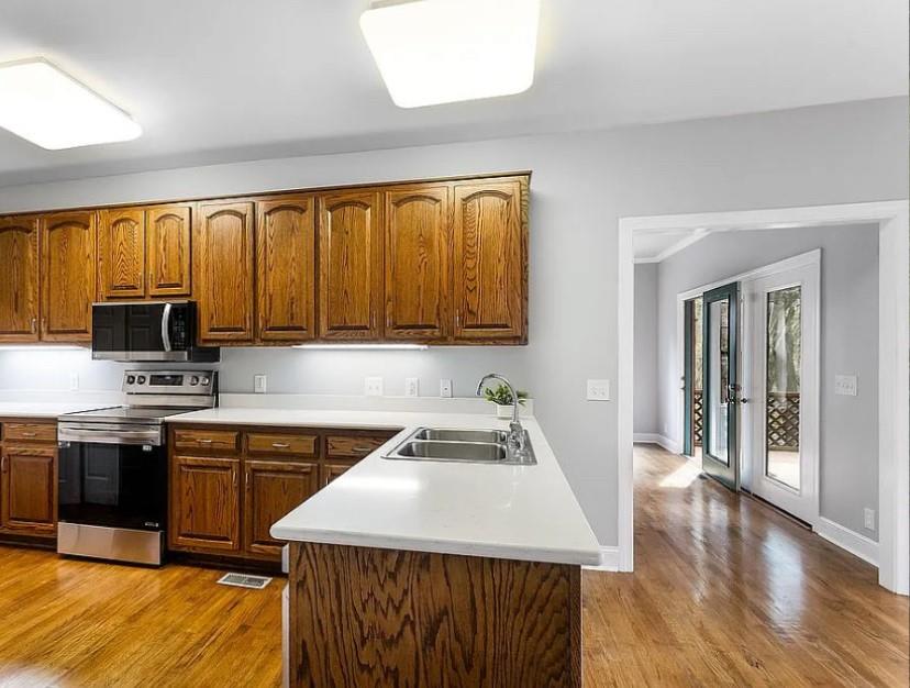 1525 Black Island Road Darien, GA 31305 - Photo 10 of 41 a kitchen with a sink a stove cabinets and a wooden floor