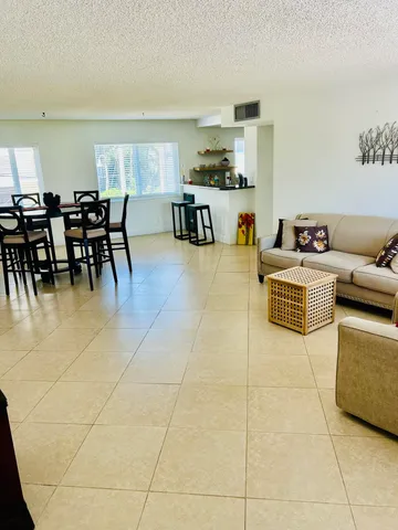 a living room with furniture a dining table and kitchen view