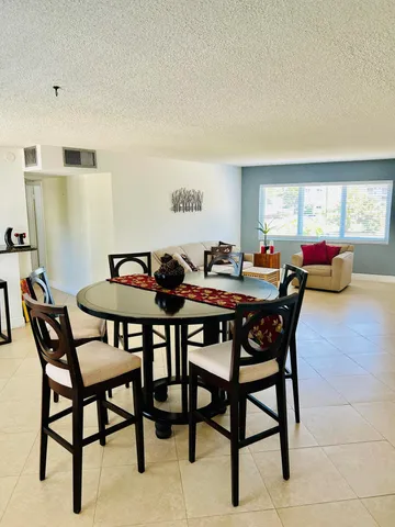a view of a a dining room with furniture window and wooden floor