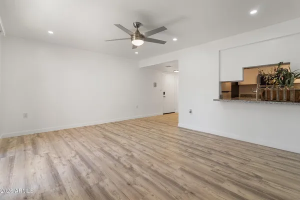 a view of an empty room with wooden floor and a window