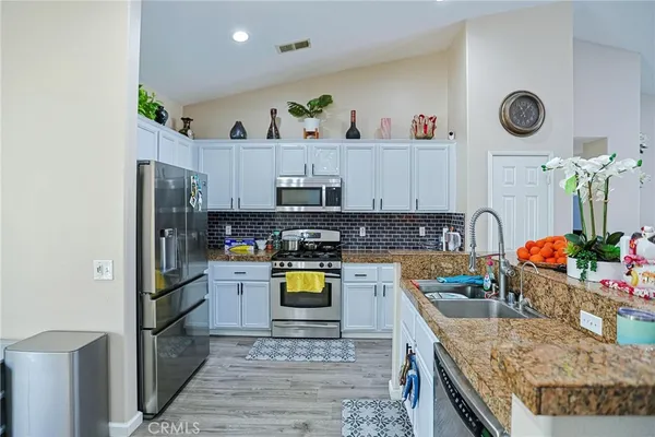 a kitchen with stainless steel appliances granite countertop a sink stove top oven and microwave