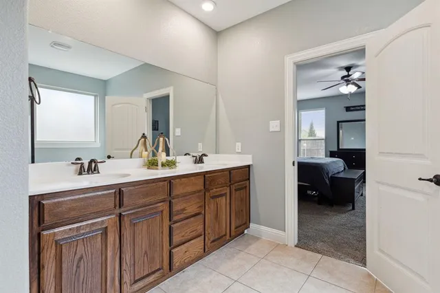a en suite bathroom with a double vanity sink and a mirror