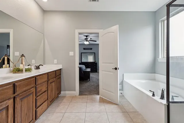 a spacious bathroom with a bathtub sink and mirror