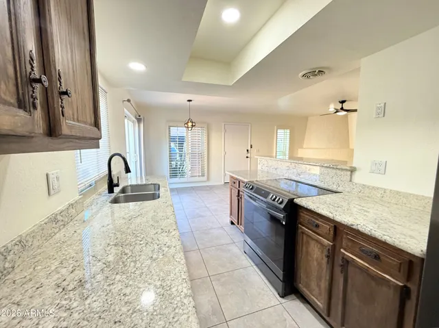 a large kitchen with stainless steel appliances granite countertop a sink and cabinets