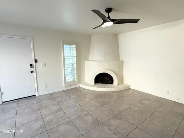 a view of a livingroom with a fireplace and a ceiling fan